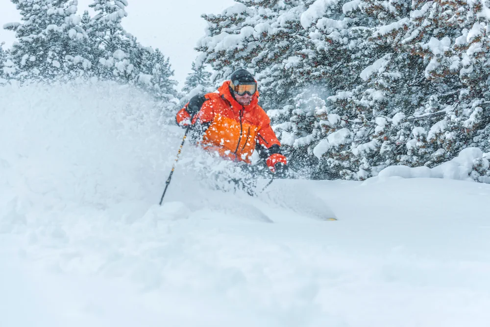 Skidkare i orange med trd i bakgrunden