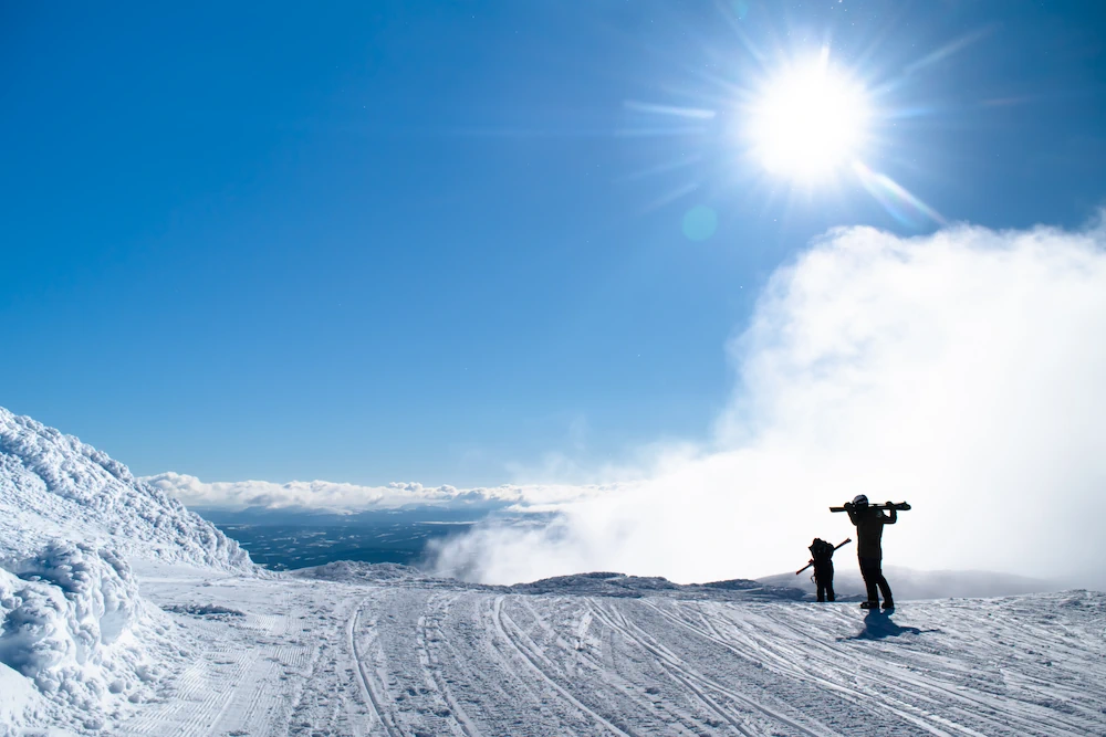 I skidbacken med bl himmel och sol