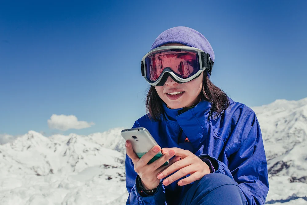 Skidåkande kvinna med telefon